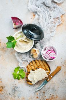 Hearty lard with garlic served with fresh bread on a rustic white table.