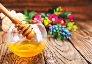fresh honey in glass bowl and on a table