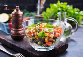 fried eggplant and red pepper, vegetables in glass bowl