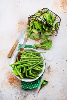 green beans in bowl and fresh leaves of mangold