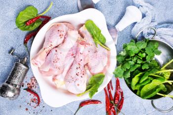 raw chicken legs with fresh spinach and spices