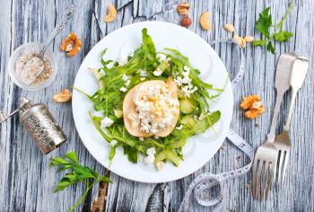 Salad with green arugula plant, pear and cottage cheese 