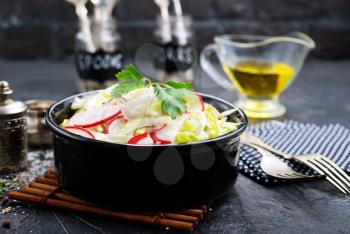 salad from fresh cabbage and radish, salad in black bowl