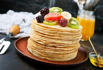pancakes with fresh fruit and honey on plate