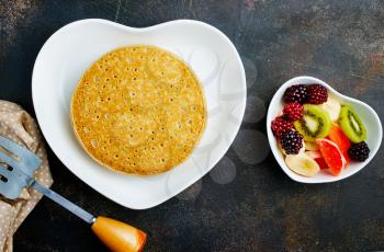 pancakes with fresh fruit and honey on plate