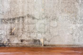 Home interior room repair concept - old gray concrete wall and dirty brown floor in repairing room 
