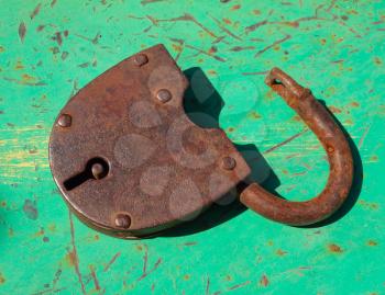 Old open rusty hinged door lock on an old painted surface