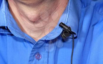 Clip microphone on a blue shirt and a part of man close up