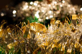 Blurred colorful Christmas background with golden tinsel and bokeh effect