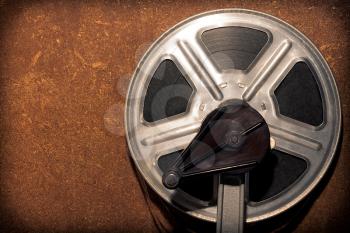 Coil with a film on a stand with a handle on a wooden background and a vignette