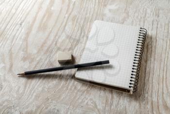 Blank sketchbook with a pencil and eraser on light wooden table background. Blank mock-up for design portfolios.