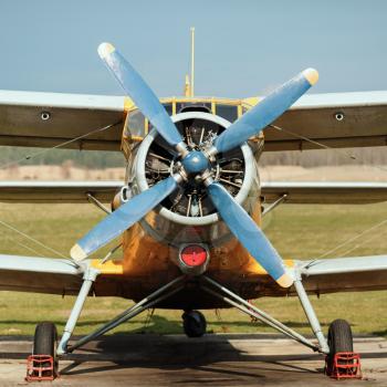 Engine and propeller of old vintage airplane. Photo in retro style. Frontal view of the propeller engine and cockpit.