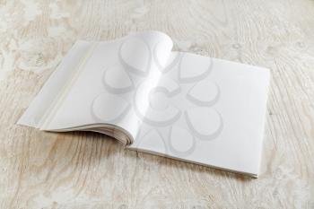 Blank opened brochure magazine on wooden background with soft shadows.  Template for graphic designers portfolios.