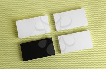 Black and white business cards on a green background. Mock-up for branding identity. Top view.