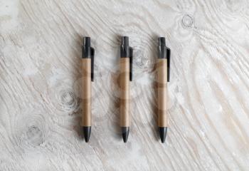 Three pens on a light wooden background. Template for design presentations and portfolios. Top view.