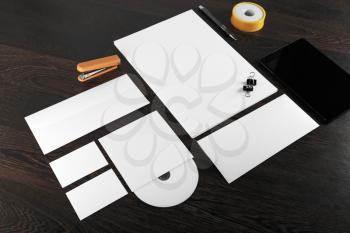 Photo of blank stationery and corporate identity template on dark wooden background. For design presentations and portfolios.