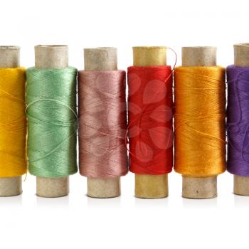 Several spools of colored threads on a white background. Close up.