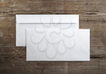 Photo of blank envelopes on a dark wooden background. Back and front. Template for branding identity. Top view.