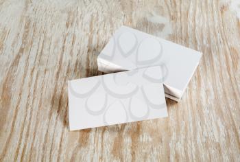 Blank business cards with soft shadows on light wooden background. Template for ID.