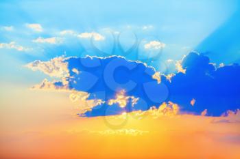 Beautiful bright sunset. Picturesque sunset sky. Colorful sky with cumulus clouds and bright sun. A great cloud covers the sun.