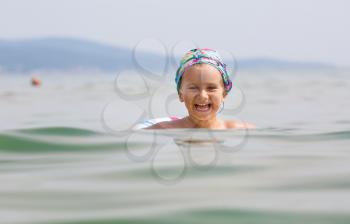 Child swims in the sea on inflatable ring on a clear sunny day. Shallow depth of field. Focus on model.
