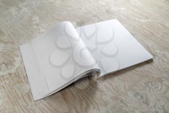 Blank opened brochure magazine on wooden background with soft shadows. Mock-up for graphic designers portfolios.