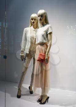 Photo of two elegant female mannequins showing clothing and accessories. Fashion concept.