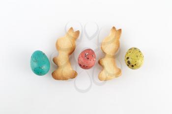 Easter eggs and delicious cookies in the shape of rabbits. Top view.