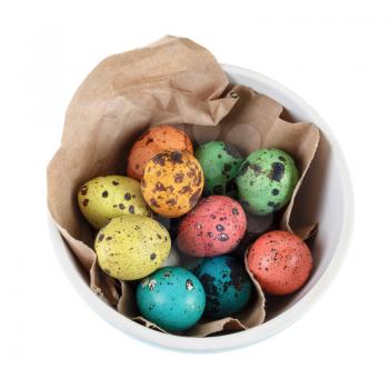 Quail eggs in the wrapping paper in a ceramic bowl on a white background. Isolated with clipping path. Top view.