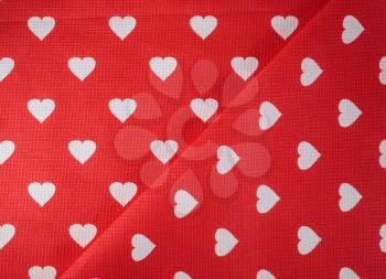 Pattern of white hearts on a bright red fabric.