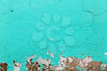 Turquoise texture. Peeling paint background.  A fragment of the old wall, painted bright turquoise paint, cracked over time. 