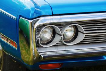 MINSK, BELARUS - MAY 07, 2016: Close-up photo of the blue Plymouth Fury 3 1972 model year. Headlights of retro car Plymouth Fury III. Selective focus.