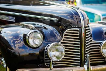 MINSK, BELARUS - MAY 07, 2016: Close-up photo of black Buick Eight 1940 model year. Old vintage car. Headlights of retro auto. Selective focus.