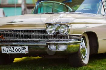MINSK, BELARUS - MAY 07, 2016: Close-up photo of beige Cadillac de Ville 1959 model year. Headlight of vintage car. Close-up detail of retro auto. Selective focus.