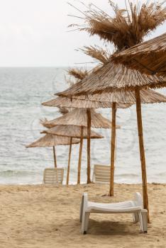 Beach umbrellas made of straw. Vertical shot. Shallow depth of field.