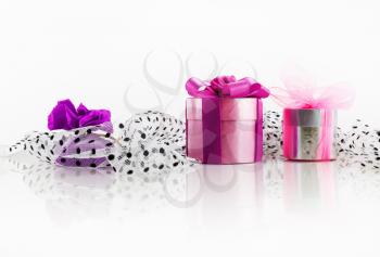 Bright decorated festive gift boxes on a light background with reflection. Christmas presents as a symbol of giving and getting presents.