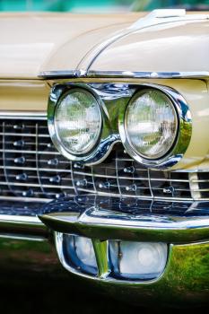 Minsk, Belarus - May 07, 2016: Close-up photo of beige Cadillac de Ville 1959 model year. Headlight of vintage car. Close-up detail of retro auto. Shallow depth of field. Selective focus.