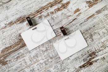 Two blank badges on vintage wooden background. Blank plastic id cards. Blank white plastic badges. Top view.