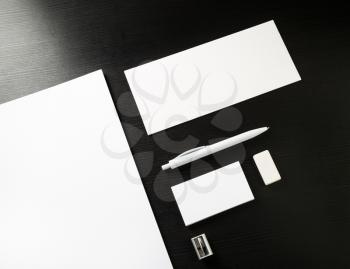 Photo of blank stationery set on black wooden table background. ID template. Mockup for branding identity for designers.
