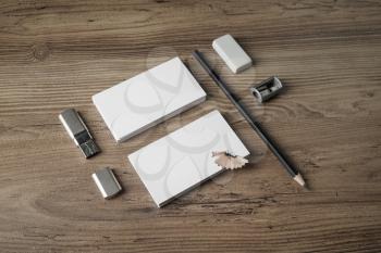 Bank business cards, pencil, eraser, flash drive and sharpener on wood table background. Blank branding template on vintage wooden table background. Photo of blank stationery.