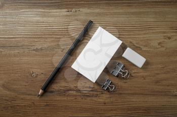 Photo of blank business cards, pencil and eraser on wood table background. Mock up for ID. Blank template for branding identity. Top view.