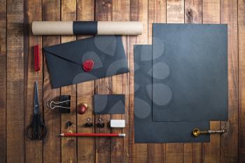 Photo of blank stationery set on wood background. Black corporate identity template for placing your design. Responsive design mockup. Top view.