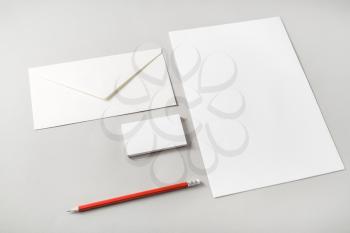 Photo of blank stationery set on paper background. Letterhead, business cards, envelope and pencil. Template for placing your design. Top view.