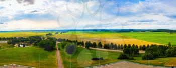 Panoramic rural landscape with green meadows, fields, trees and blue sky with clouds.. Minsk region, Belarus.