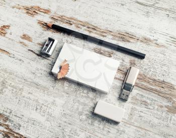 Photo of blank stationery on vintage wooden table background. Business cards, pencil, eraser, flash drive and sharpener.