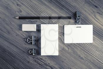 Blank stationery set for placing your design. Business card, badge, pencil and eraser on wood background. Top view.