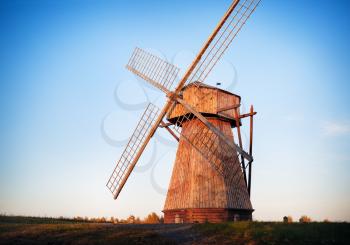 Traditional old wooden windmill in the evening against the cloudless sky.