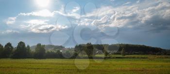 Rural landscape. Field, forest and sky with clouds. Panorama shot