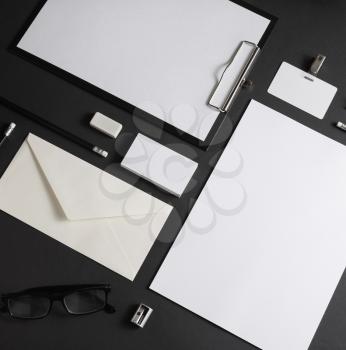 Photo of blank corporate stationery set on black paper background. Responsive design template.