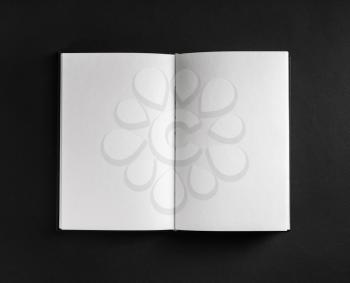 Book, notebook or booklet with blank pages on black paper background. Top view. Flat lay.